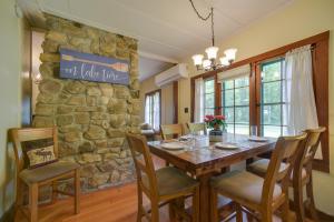 a dining room with a stone wall and a table and chairs at Lakefront Adirondack Getaway with Beach and Kayaks! in Lake Pleasant