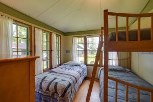 a bedroom with two bunk beds and windows at Lakefront Adirondack Getaway with Beach and Kayaks! in Lake Pleasant