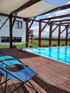 una terraza con sillas y una piscina en Vila Sol en Prejmer