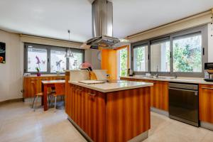 uma grande cozinha com armários de madeira e uma bancada em Lushville - Luxurious Villa with Pool in Valencia em Campo Olivar