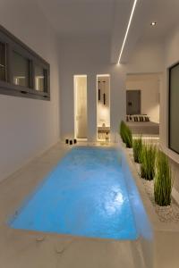 フィラにあるLinea Luxury Suitesの白い部屋の大きな青いプール