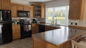 a kitchen with wooden cabinets and a black refrigerator at Douglas Lake Paradise A in Saint John