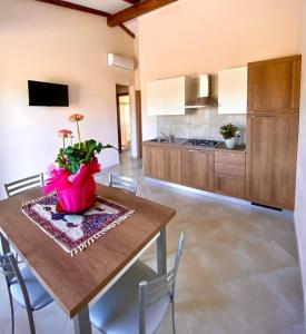 eine Küche mit einem Tisch und einer Blumenvase darauf in der Unterkunft Casa Ruris - Country residence in Briatico