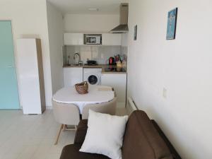 un piccolo soggiorno con divano e tavolo di Antibes les Pins 2 Pièces vue mer piscine parking a Antibes