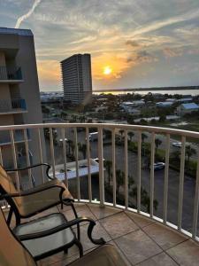 a balcony with two chairs and a view of a city at Ocean House 1806 in Gulf Shores