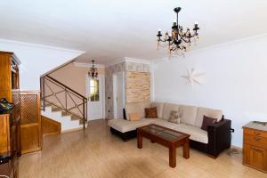 a living room with a couch and a staircase at Casa Sagittarius Ocean view in San Marcos