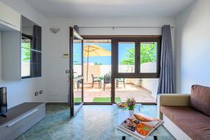 sala de estar con sofá y mesa en 5 - Relax e comfort in casa con giardino - Sa Crai Apartments Sardinian Experience en Lotzorai
