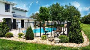 a black fence with a pool in front of a house at Days Inn by Wyndham Battlefield Rd/Hwy 65 in Springfield