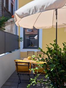 un patio con sombrilla, mesa y sillas en Boavista Luxury Villas, en Oporto