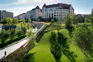 a green park with buildings in the background at Garden View Apartment in Budapest