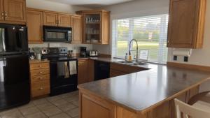 uma cozinha com armários de madeira e um frigorífico preto em Douglas Lake Paradise AB em Saint John