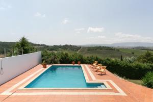 - une piscine sur une terrasse avec vue sur les collines dans l'établissement Alma Country House, à Carvalhal