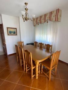 Un comedor con mesa y sillas de madera. en O Lar de Jose, en Monforte de Lemos