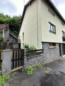 a house with a stone wall and a gate at Villa Janchrisma MontDore 11pers in Le Mont-Dore