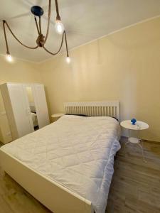 een slaapkamer met een wit bed en een tafel bij La Casa di Maria in Ardore Marina