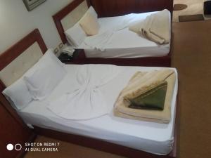 duas camas num quarto de hotel com lençóis brancos em Salvatore Room with Breakfast-Ras El Bar em Ras El Bar