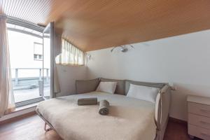 Chic & Modern apartment with terrace في بولونيا: غرفة نوم بسرير ونافذة كبيرة