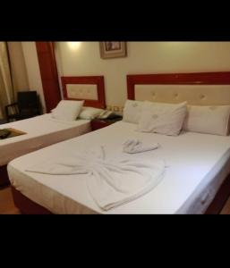 1 dormitorio con 2 camas con sábanas blancas en Salvatore Room with Breakfast-Ras El Bar, en Ras El Bar