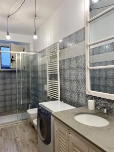 een badkamer met een wastafel en een wasmachine bij La Casa di Maria in Ardore Marina
