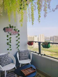 a balcony with two chairs and a table and a window at Paris Suite By Hey Studio's in Ghaziabad