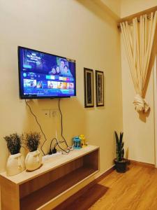 a living room with a flat screen tv on a wall at Paris Suite By Hey Studio's in Ghaziabad