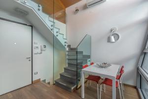 Chic & Modern apartment with terrace في بولونيا: غرفة طعام مع طاولة ودرج