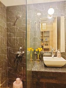 a bathroom with a sink and a shower at Paris Suite By Hey Studio's in Ghaziabad