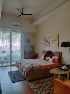 a bedroom with a large bed and a table at Paris Suite By Hey Studio's in Ghaziabad