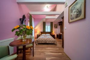 ein Schlafzimmer mit einem Bett und einem Tisch mit Blumen darauf in der Unterkunft Hotel Modrzewiówka in Lanckorona