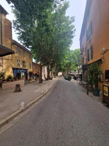 an empty street in a town with buildings and trees at Cool Blue Cotignac Studio in the heart of the village in Cotignac +8 photos
