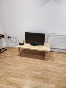 a wooden coffee table with a television on top of it at Sparrow & City Pad 5 in London