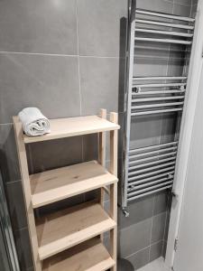 a bathroom with wooden shelves in a shower at Sparrow & City Pad 5 in London