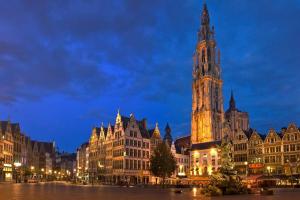 a large clock tower in a city at night at Spacious 2BDR Apartment, Antwerp center in Antwerp
