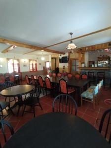 a dining room with tables and chairs and a bar at Haškovna - tradice zájezdního hostince u Prachovských skal in Ohaveč