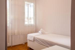 um quarto branco com 2 camas e uma janela em Flat with Large Balcony in Izmir em Esmirna