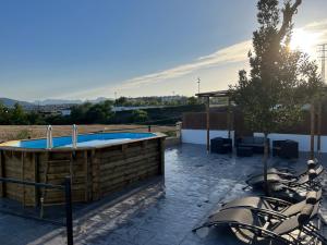 un patio con bañera de hidromasaje, mesa y sillas en Apartamentos Sierra de Las Nieves, en Ronda