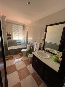 een badkamer met een wastafel, een bad en een toilet bij Los Girasoles in Olvera