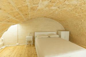 1 dormitorio con 1 cama en una pared de piedra en Suite16 & spa, en Barletta