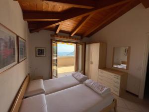 - une chambre avec un canapé blanc et une fenêtre dans l'établissement Residence Mirabel, à Tignale