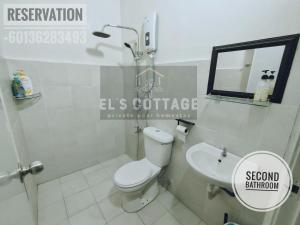 a white bathroom with a toilet and a sink at El's Cottage Homestay in Pekan