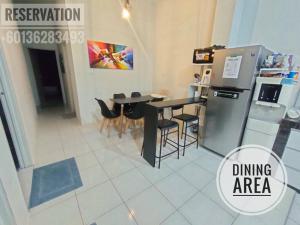 a kitchen with a dining area with a table and a refrigerator at El's Cottage Homestay in Pekan