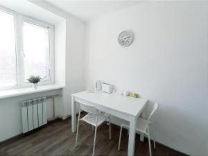 a white dining room with a white table and chairs at Білі 1 кімнатні апартаменти Сіті- центр 4 поверх 9 поверхового будинку in Mykolaiv