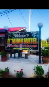 a sign for a tainan motel in a parking lot at Dtahan Motel Taman Negara in Kuala Tahan