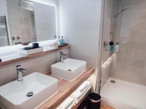 a white bathroom with a sink and a shower at Rooms at The Deck, Penarth in Cardiff