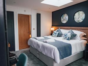 a bedroom with a large bed with two mirrors on the wall at Rooms at The Deck, Penarth in Cardiff