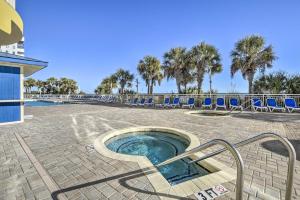 a hot tub in a patio with chairs and palm trees at 2 Mi to Barefoot Landing Condo with Beach Access! in Myrtle Beach