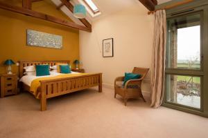 een slaapkamer met een bed, een stoel en een raam bij East Lodge in Bedale