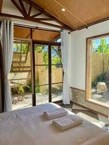 a bedroom with a bed and a large window at Pousada Pataca de prata - Pousada de Época in Petrópolis