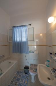 y baño con bañera, aseo y lavamanos. en Classic Guesthouse Nafplion, en Nauplia