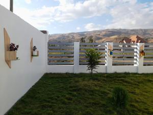 una recinzione bianca con vista sulle montagne di La-Domek Traveller's home a Mbeya
